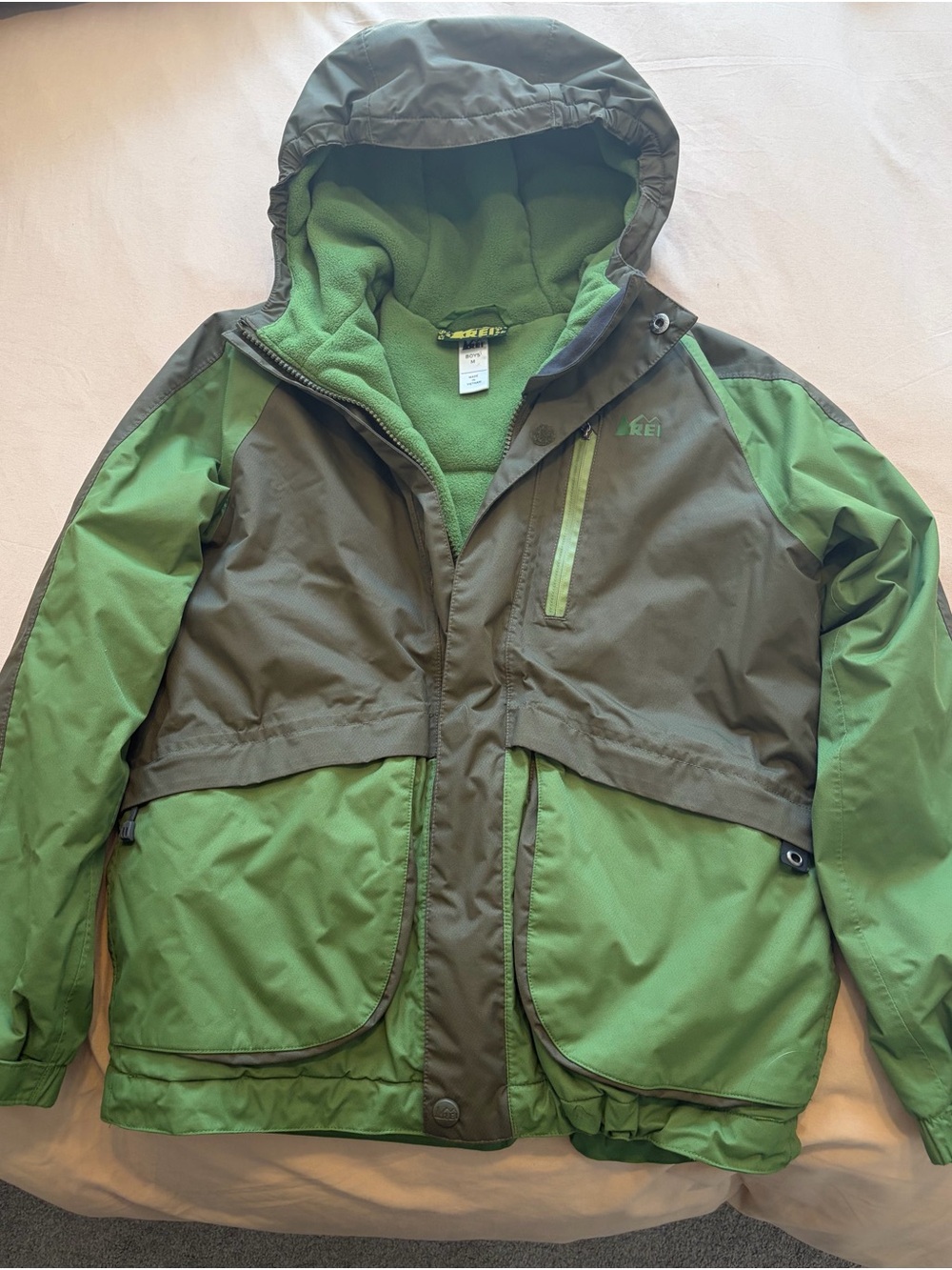 REI Boys Two-Tone Green Hooded Rain Jacket with fleece inner layer.